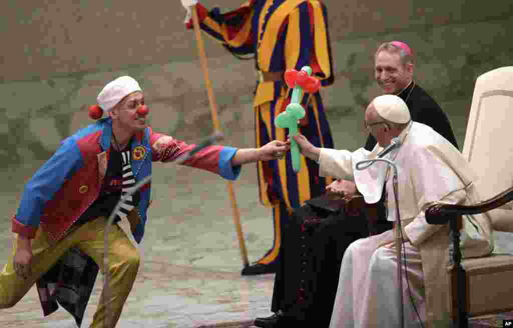 Paus Fransiskus menerima sebuah balon berbentuk bunga pada saat berlangsungnya pertunjukan Golden Circus di Hall Paul VI di Vatikan.