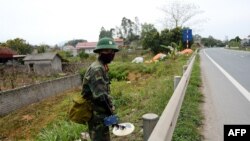 Vietnamese military personnel uses a mine-sweeper while patrolling the road between Hanoi and the Dong Dang railway station near the Chinese border in Lang Son province, Feb. 23, 2019.