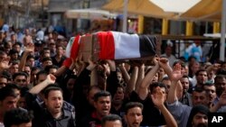 16일 바그다드 남부에서 테러 공격으로 사망한 경찰의 장례식이 열렸다. 주민들이 테러를 비난하는 구호를 외치면서 관을 옮기고 있다. (자례사진)