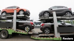 FILE - Cars made by GM Korea are seen on trucks in a yard of GM Korea's Bupyeong plant before they are transported to a port for export, in Incheon, west of Seoul, Aug. 9, 2013.