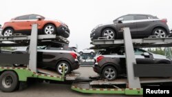 FILE - Cars made by GM Korea are seen on trucks in a yard of GM Korea's Bupyeong plant before they are transported to a port for export, in Incheon, west of Seoul, Aug. 9, 2013. 