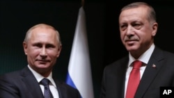 Russian President Vladimir Putin, left, and his Turkish counterpart Recep Tayyip Erdogan shake hands after a joint news conference at the new Presidential Palace in Ankara, Turkey, Dec. 1, 2014. 