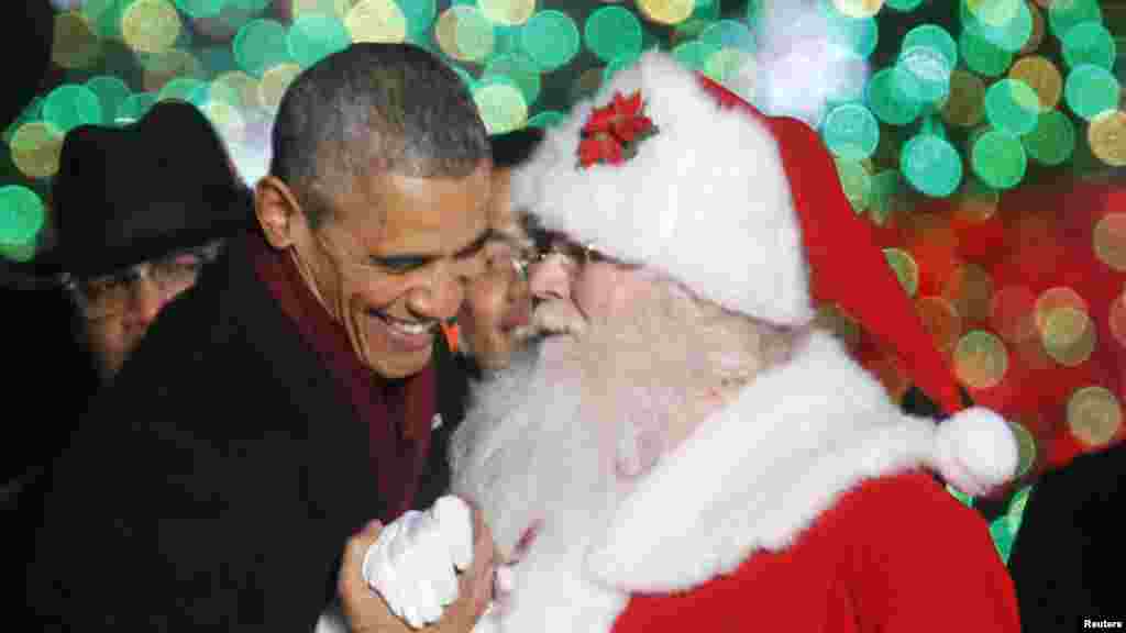 Le Président américain Barack Obama salue un homme déguisé en Père Noël lors de la 92e illumination annuelle nationale de l&#39;Arbre de Noël sur l&#39;Ellipse près de la Maison Blanche à Washington, 4 décembre 2014.