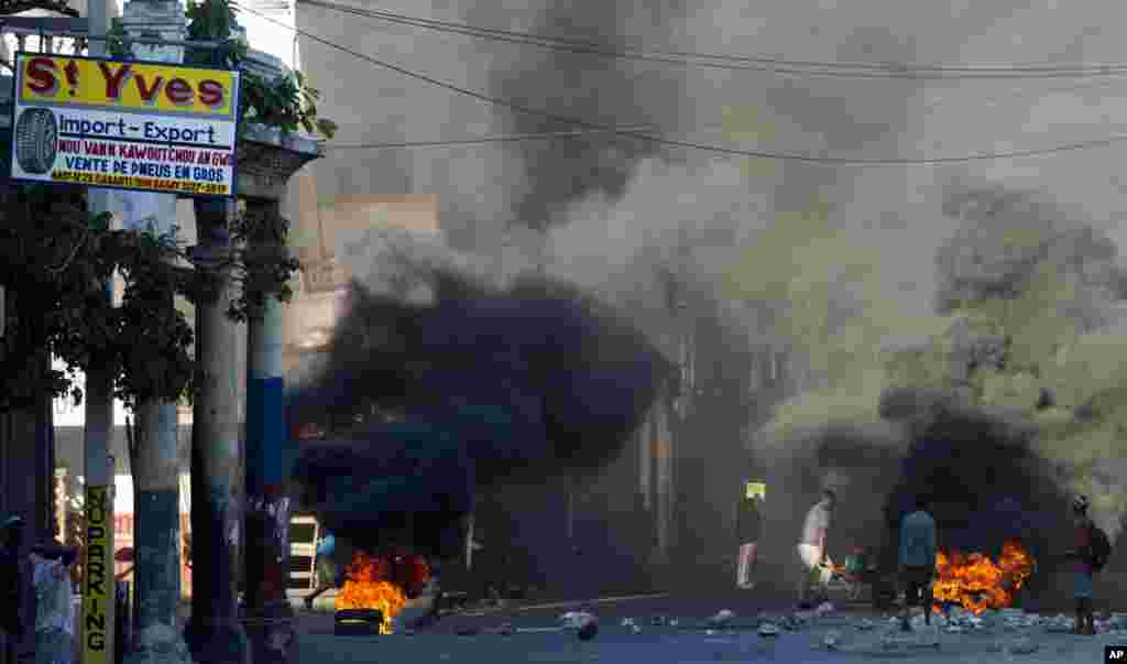 Burning tires and large rocks serve as barricades blocking a road on the third day of countrywide protests over allegations of government corruption, in Port-au-Prince, Haiti.