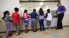 Anak-anak imigran mengantre makanan di kafetaria Pusat Penampungan Karnes County, di Karnes City, Texas, 10 September 2014.