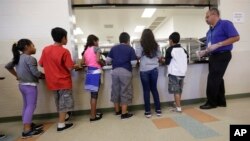 FILE - Detained immigrant children line up in the cafeteria at the Karnes County Residential Center, a detention center for immigrant families, in Karnes City, Texas, Sept. 10, 2014. 