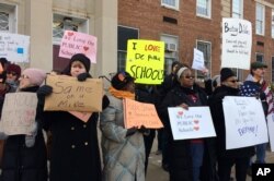 Protesters gather outside Jefferson Middle School in Washington, Feb. 10, 2017, where Education Secretary Betsy DeVos paid her first visit as education secretary in a bid to mend fences with educators after a bruising confirmation battle.