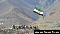 FILE - Afghan resistance movement and anti-Taliban uprising forces stand guard on a hilltop in the Astana area of Bazarak in Panjshir province on Aug. 27, 2021.