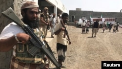 FILE - Yemeni fighters secure a building where UAE Red Crescent distribute aid to displaced people in Al-Mokha, Yemen, March 6, 2018. 