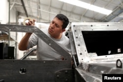 An employee works on the door of an armored vehicle at the garage of Blindajes EPEL company in Mexico City, Mexico, April 9, 2018.