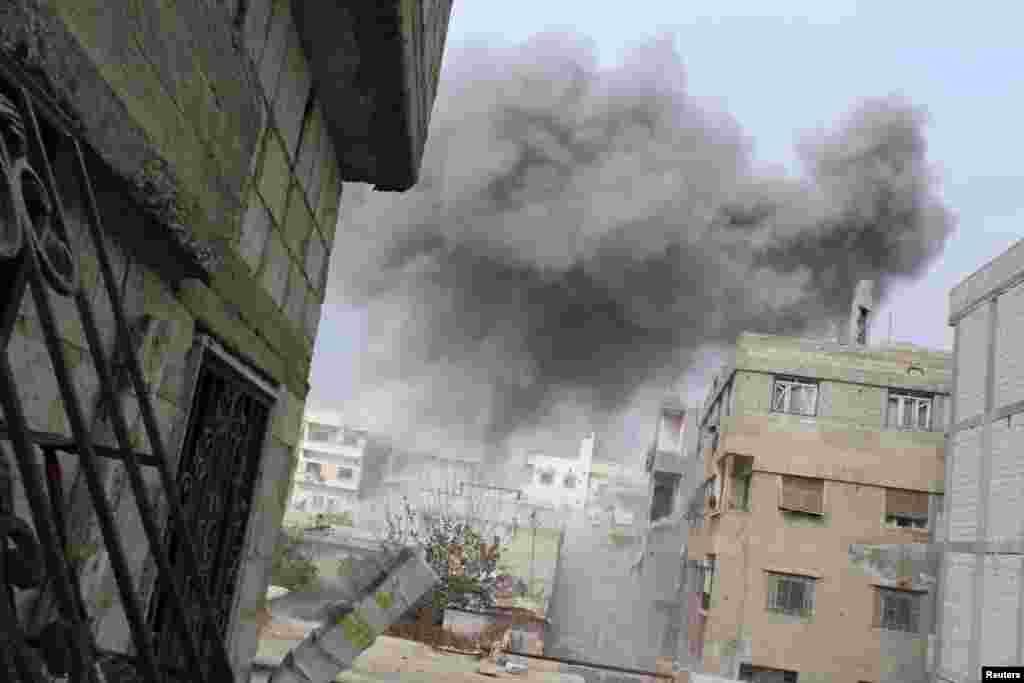 Api mengepul dari apa yang disebut para aktivis sebagai tong peledak yang dilempar dari helikopter di Daria di luar Damascus, 12 Januari 2014. 
