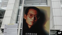 Activists hold a picture of Liu Xiaobo outside the China's liaison office in Hong Kong.