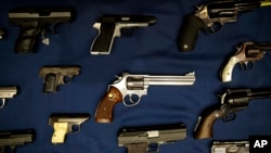 FILE - Guns seized by the police are displayed during a news conference in New York.