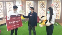 Rektor Ubaya Benny Lianto memberikan secara simbolis bantuan pembelajaran daring kepada mahasiswa (foto Petrus Riski/VOA).