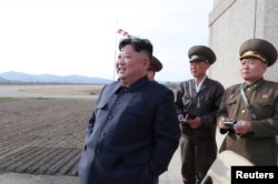 FILE - North Korean leader Kim Jong Un, along with two military officials, observes a Korean People's Air Force training flight, on April 16, 2019. Photo released April 17, 2019 by North Korea's Central News Agency (KCNA).