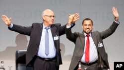 Mohammed Chouaib, head of delegation from the U.N.-recognized government in the eastern city of Tobruk, Libya, left, and Dr. Saleh Almkhozom, Second Deputy Chairman of the Libyan General National Congress, react after signing a U.N.-sponsored deal aiming to end Libya's conflict, Dec.17, 2015, in Sikhrat, Morocco. 