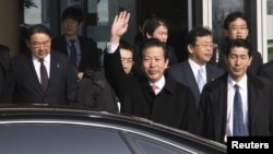 Japan's New Komeito's party leader Natsuo Yamaguchi (C) accompanied by the Japanese ambassador to China Masato Kitera (L) waves his hand as he walks out from the VIP exit of Beijing Capital International airport, January 22, 2013.