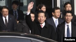 Utusan Jepang, Natsuo Yamaguchi (tengah) melambai saat tiba di bandara internasional di Beijing hari Selasa (22/1). 
