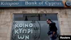 A man walks past a branch of Bank of Cyprus in Nicosia, March 31, 2013.