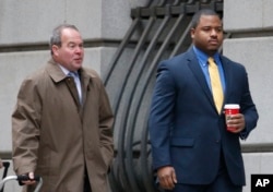 William Porter, right, one of six Baltimore city police officers charged in connection to the death of Freddie Gray, walks into a courthouse with his attorney Joseph Murtha for jury selection in his trial, Nov. 30, 2015, in Baltimore.