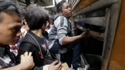 Penumpang berusaha naik sebuah kereta di Stasiun Senen lewat jendela (foto: dok). Masa mudik lebaran adalah masa yang paling sibuk bagi jasa layanan kereta api.