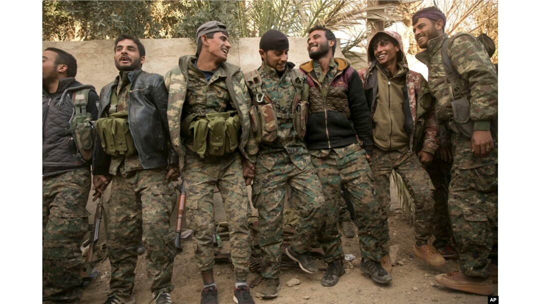 U.S.-backed Syrian Democratic Forces fighters celebrate their territorial gains over Islamic State militants in Baghuz, Syria, March 19, 2019.