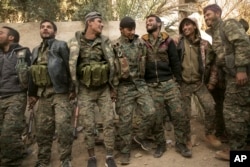 Para tentara Pasukan Demokratik Suriah yang didukung AS merayakan kemenangan merebut wilayah ISIS di Baghuz, Suriah, 19 Maret 2019.
