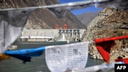 Prayer flags hang before Zangmu Hydropower Station in Gyaca county in Lhoka, or Shannan prefecture, southwest China's Tibetan Autonomous Region, Nov., 23, 2014.