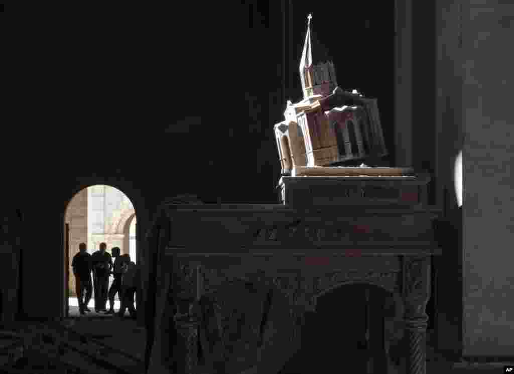A model of the Holy Savior Cathedral stands inside the Cathedral, damaged by shelling during a military conflict, in Shushi, outside Stepanakert, the separatist region of Nagorno-Karabakh, Tuesday, Oct. 13, 2020. The latest outburst of fighting between Az