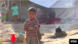 Anak-anak berkumpul menunggu pembagian bantuan pangan di kamp di Kabul, Afghanistan.
