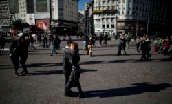 Couples dance a tango during a demonstration demanding they be allowed to practice in open spaces amidst ongoing restrictions due to surging new coronavirus caseloads, in Buenos Aires, Argentina, Saturday, May 29, 2021.