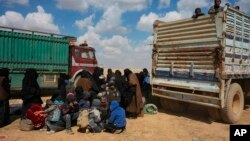 Women and children gather near trucks after being evacuated from the last territory held by Islamic State militants outside Baghuz, Syria, March 6, 2019.