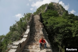 A man rests while working on the reconstruction of the Jiankou section of the Great Wall, in Huairou District, north of Beijing, China, June 7, 2017.