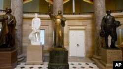 FILE - The statue of missionary Junipero Serra, center, is displayed in Statuary Hall, also known as the Old Hall of the House, on Capitol Hill in Washington, July 2, 2015.