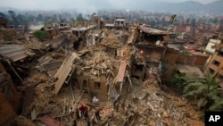 Rescue workers remove debris as they search for victims of earthquake in Bhaktapur near Kathmandu, Nepal, April 26, 2015. Nepal's parliament approved new laws to allow the government to spend billions of dollars pledged by foreign donors on earthquake reconstruction.