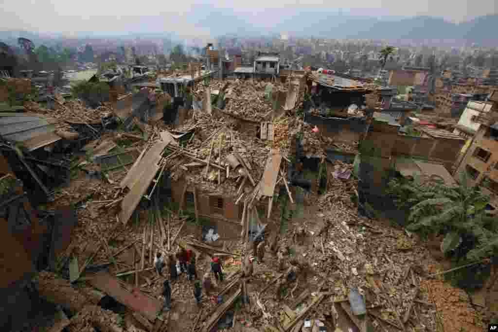 Tim pencari dan upaya penyelamatan memindahkan reruntuhan ketika mereka mencari korban gempa bumi di Bhaktapur dekat Kathmandu, Nepal, 26 April 2015.