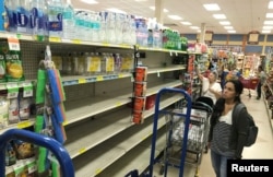 A shopper in Sedano's Supermarket looks at nearly empty water shelves in the Little Havana neighborhood in Miami, Florida, Sept. 5, 2017. Residents are preparing for the approach of Hurricane Irma.