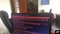 Peringatan serangan siber di layar komputer yang dilaporkan menyandera file-file komputer untuk mendapatkan tebusan, sebagai bagian dari serangan siber masif internasional di sebuah komputer di Kiev, Ukraina, Selasa, 27 Juni 2017 (foto: Oleg Reshetnyak via AP)