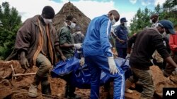 Men retrieve the body of a teenager killed by mudslides triggered by Cyclone Idai, in Chimanimani, Zimbabwe, March 22, 2019.