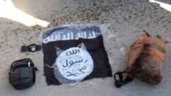 This photo provided by the Kurdish-led Syrian Democratic Forces shows the flag and bags of Islamic State group fighters arrested by the Kurdish-led Syrian Democratic Forces after they attacked Gweiran Prison, in Hassakeh, Syria, Jan. 21, 2022.