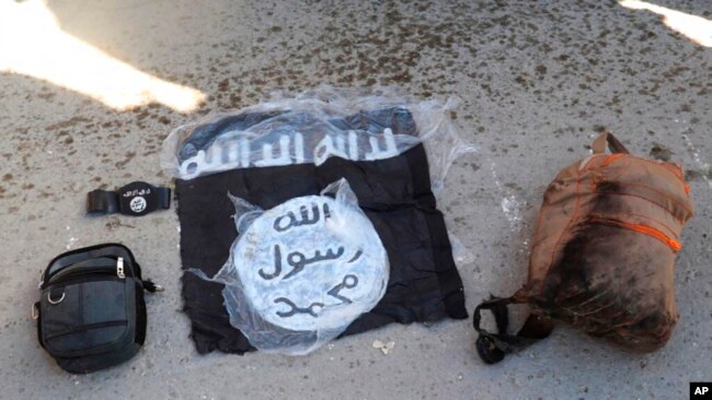 FILE - An Islamic State flag and other possessions from IS group fighters are seen in Hassakeh, Syria, Jan. 21, 2022.