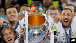 Les joueurs du Real Madrid célèbrent avec le trophée après leur victoire en finale de la Chamions League au stade San Siro, à Milan en Italie, 28 mai 2016.