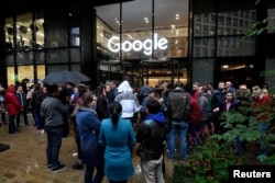 Workers stand outside the Google offices after walking out as part of a global protest over workplace issues, in London, Britain, Nov. 1, 2018.