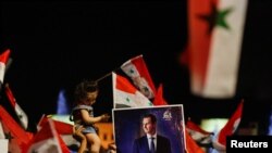 Pendukung Presiden Suriah Bashar al-Assad bersiap merayakan hasil pemilihan presiden di Damaskus, Suriah, 27 Mei 2021. (REUTERS / Omar Sanadiki)
