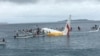 People are evacuated from an Air Niugini plane crashed in the waters in Weno, Chuuk, Micronesia, in this picture obtained from social media. 