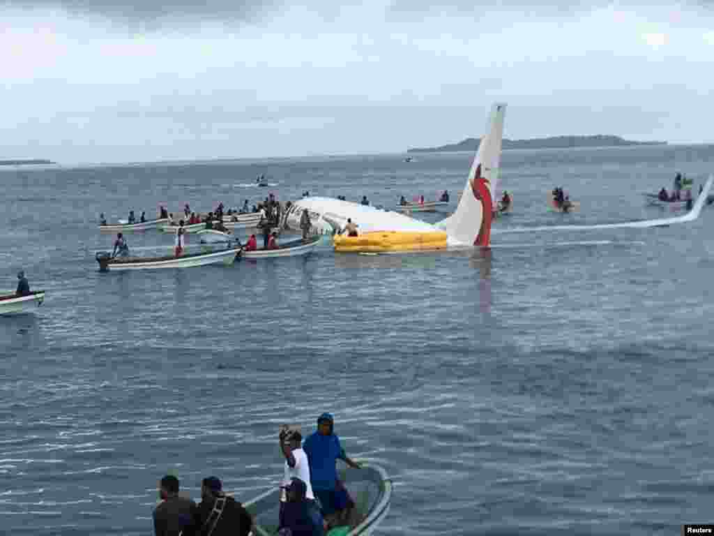 People are evacuated from an Air Niugini plane crashed in the waters in Weno, Chuuk, Micronesia, in this picture obtained from social media.