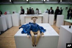 A toy doll is displayed as visitors look at items presented at the Museum of Broken Relationships in Pristina, Kosovo, May 3, 2018.
