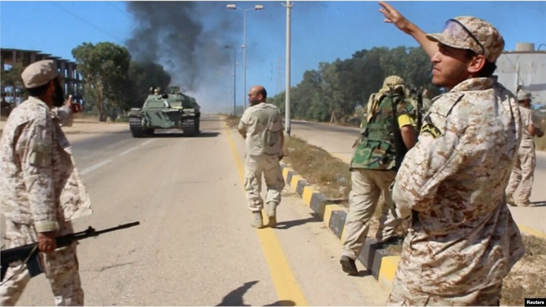 Soldiers from a force aligned with Libya's new unity government walk along a road during an advance on the eastern and southern outskirts of the Islamic State stronghold of Sirte, in this still image taken from video on June 9, 2016.