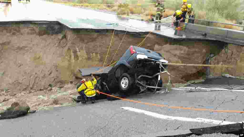 In this photo provided by the CAL FIRE/Riverside County Fire Department, emergency crews respond after a pickup truck crashed into a hole caused by the collapse of an elevated section of Interstate 10 in Desert Center, California, July 19, 2015. 
