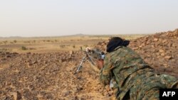 FILE - A Tuareg fighter of the Coordination of Movements of the Azawad (CMA) points his weapon near Kidal, northern Mali, Sept. 28, 2016. 